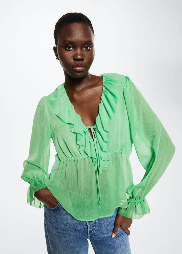 Blusa en tejido ligero y fluido con escote de pico, manga larga, fruncido elástico en la cintura y volantes, color verde, de Mango. Puedes comprarla a 19,99 euros.