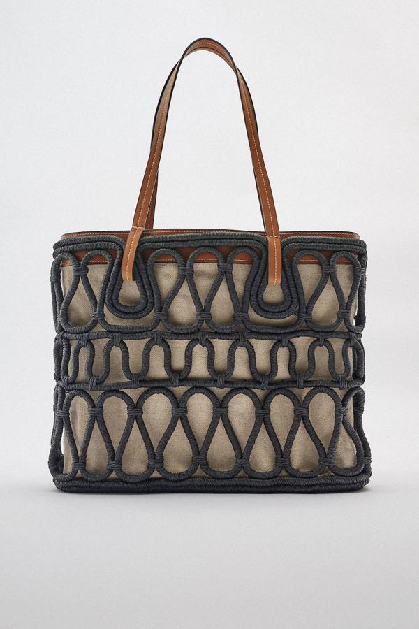Bolso shopper en combinación de materiales, con cuerpo de estructura de tiras tubulares, interior en tejido de canvas y asas de hombros, en tonos negro, marrón y beige, de Zara. Está disponible a 79,95 euros.