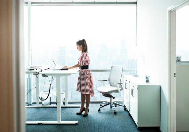 Elegant businesswoman working alone with laptop in office building