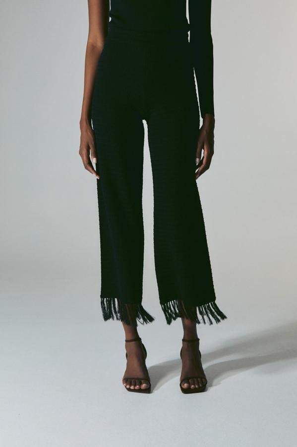 Una propuesta que no dejará a nadie indeferente. Un pantalón clásico de color negro remtado con flecos. Pantalón de Sfera (39,99 euros). 