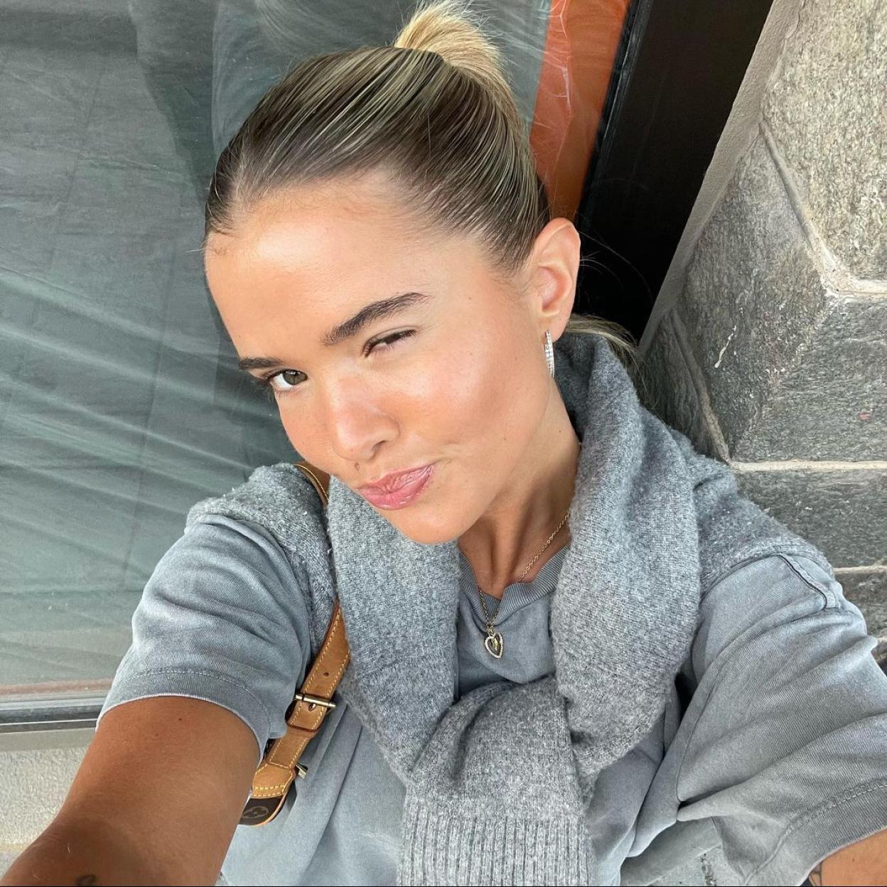 La influencer Matilda Djerf con una piel lisa, joven y sin imperfecciones guiñando un ojo a cámara. 