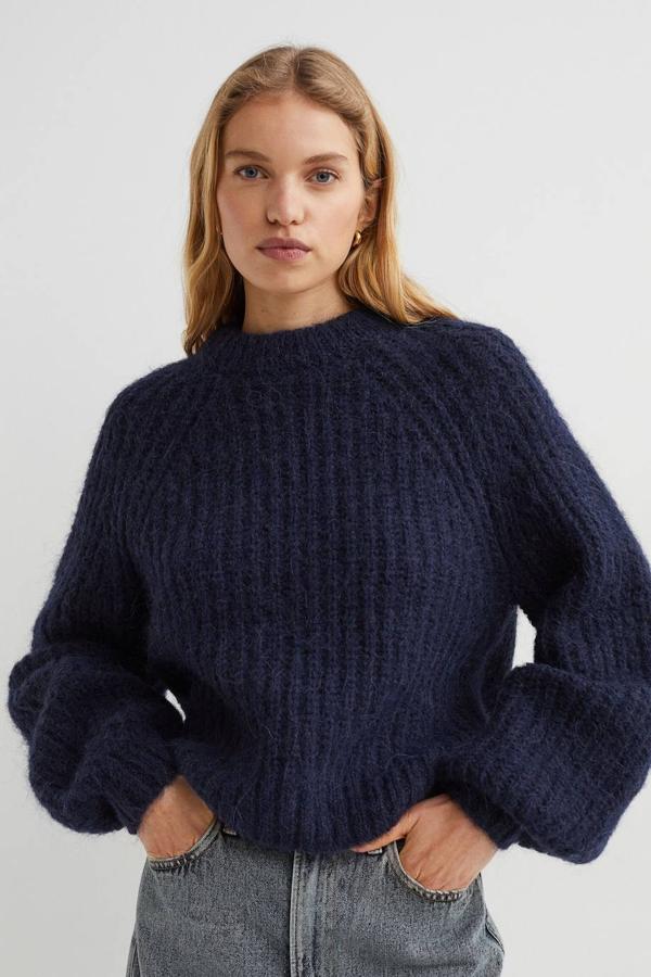 Jersey de punto canalé suave en tejido mezcla de lana y lana de alpaca con mangas raglán amplias y cuello redondo, en azul oscuro. Cómpralo por 49,99 euros.