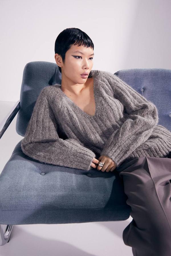 Jersey en punto de canalé mezcla de lana y alpaca con silueta amplia, escote de pico y mangas largas, en tono gris. Está disponible por 59,99 euros.