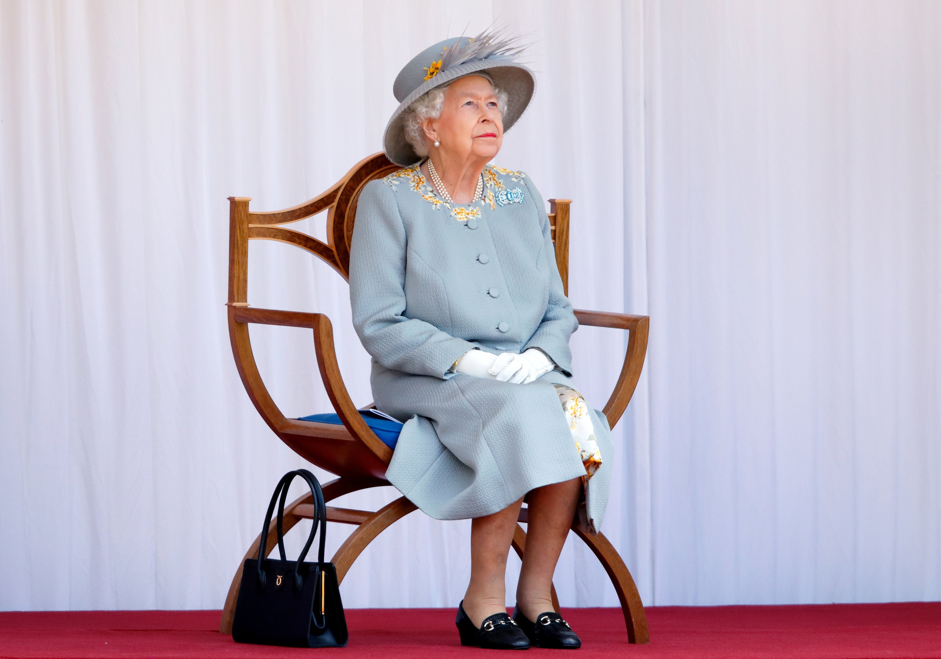 WINDSOR, UNITED KINGDOM - JUNE 12: (EMBARGOED FOR PUBLICATION IN UK NEWSPAPERS UNTIL 24 HOURS AFTER CREATE DATE AND TIME) Queen Elizabeth II watches a flypast by the RAF Red Arrows as she attends a military parade, held by the Household Division (during which The Queen's Colour of F Company Scots Guards will be trooped) in the Quadrangle of Windsor Castle, to mark her Official Birthday on June 12, 2021 in Windsor, England. For the second consecutive year The Queen's Birthday Parade, known as Trooping the Colour, hasn't been able to go ahead in it's traditional form at Buckingham Palace and Horse Guards Parade due to the ongoing COVID-19 Pandemic. (Photo by Max Mumby/Indigo - Pool/Getty Images)