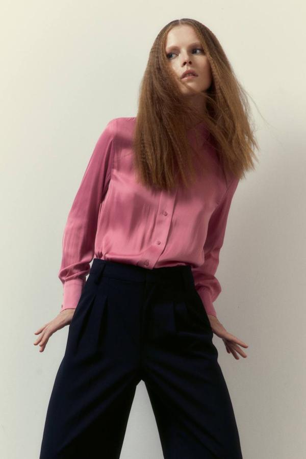 Camisa satinada fluida con manga larga termina en puño, cuello solapa y cierre de botones en la parte frontal, color rosa, de Sfera. Tiene un precio de 29,99 euros.