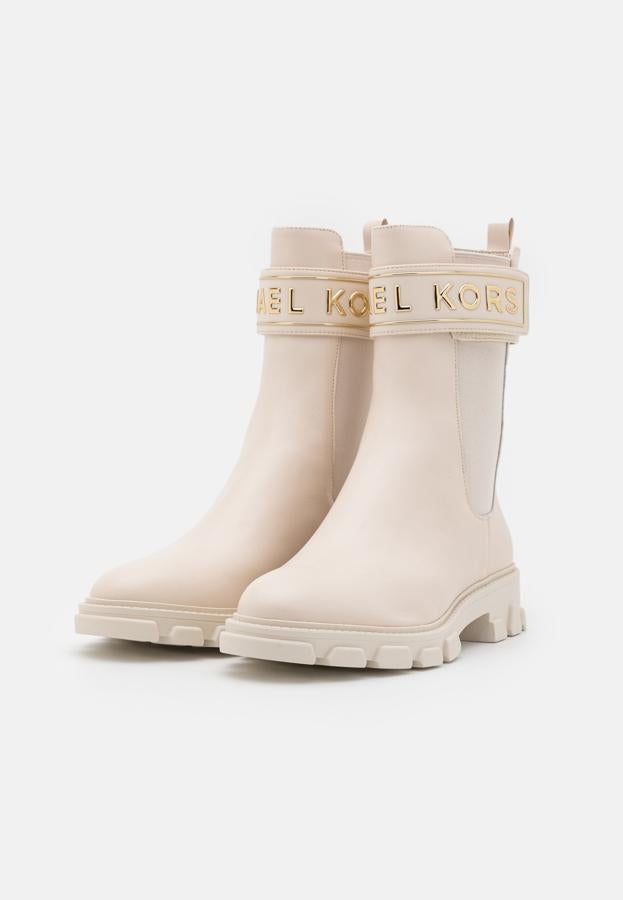 Botas de color crema con cierre con su respectivo logotipo en dorado. Cuenta con detalles del mismo color para generar contraste. Son de Michael Kors. Precio: 274,95 €.