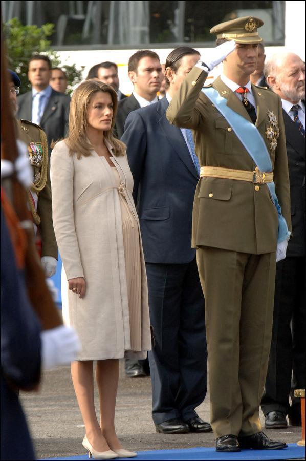 Las apariciones públicas de la reina Letizia embarazada son contadas. Sin embargo, nuestro look favorito de la monarca con tripita es este que llevó durante el Día de la Hispanidad de 2005, cuando apostó por tonos neutros y lució un abrigo a juego con un vestido midi.