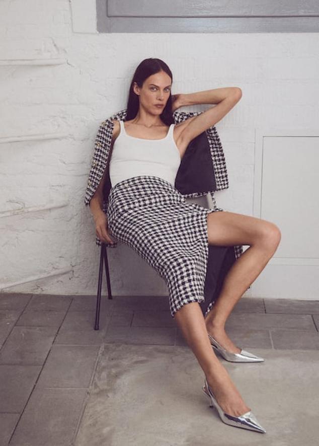 Las faldas fluidas con estampado de cuadros vichy han dado paso a propuestas más otoñales, en tejidos más gruesos. Falda midi con abertura de Mango (39,99 euros). 