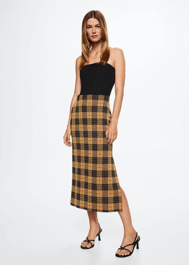 Falda midi lápiz en tejido de algodón con tiro alto, corte entallado y abertura lateral, en estampado de cuadros mostaza, de Mango. Cómpralo por 25,99 euros.