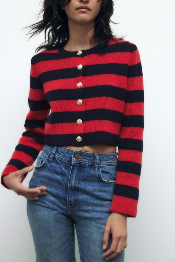 Una combinación de colores, el azul marino y el rojo, que convierte a esta chaqueta en un prendas que no pasará desapercibida. Cárdigan con botones dorados de Zara (29,99 euros). 