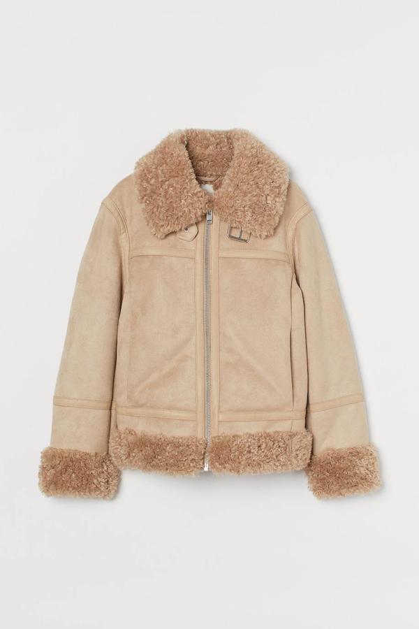 Chaqueta en tejido efecto serraje con forro de borreguillo a tono, silueta relajada, cuello solapa, bolsillos laterales y cierre frontal de cremallera, en beige, de H&M. Puedes comprarla a 79,99 euros.