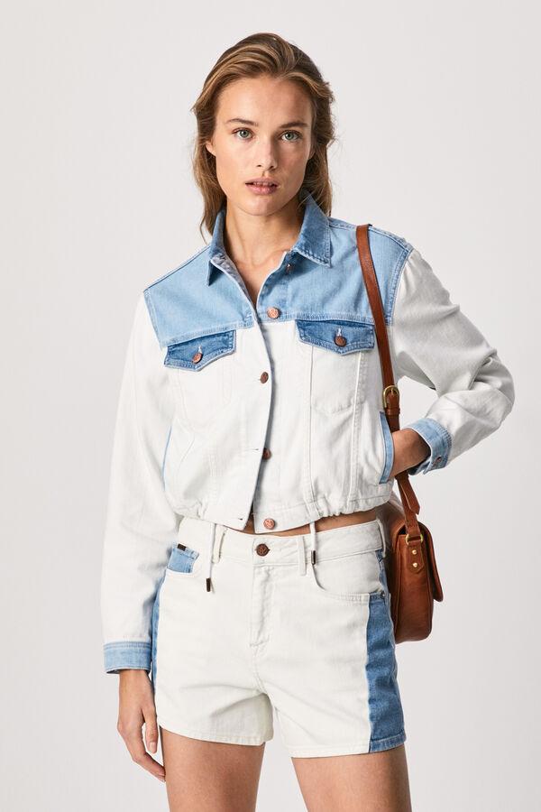 Cazadora vaquera crop, de tejido denim elástico y flexible. Efecto lavado mezcla blanco y azul, bolsillos frontales con solapa y botón y bajo ajustable con cordón. Precio: 65 euros, en Springfield. Cómpralo aquí