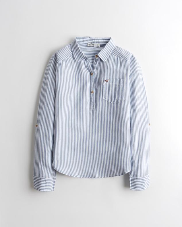 Camisa de rayas azul claro con media tapeta abotonada. Su diseño holgado y drapeado sigue a la perfección la tendencia favorita de las danesas. Es de Hollister. Precio: 39 €.