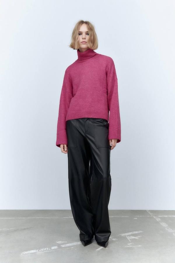 Jersey de punto con corte relajado, cuello subido, mangas largas ligeramente acampanadas y terminaciones en rib, color fucsia, de Zara. Su coste es de 29,95 euros.