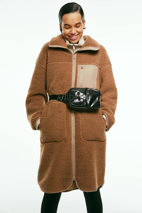 Chaqueta larga en tejido de borreguillo con cuello convertible, cierre de cremallera frontal, manga larga, corte oversize y tres bolsillos, en marrón, de H&M. Está disponible a 54,99 euros.