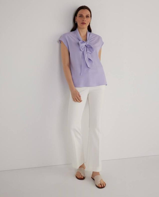 Camisa fluida de manga corta con cuello amplia decorado con lazada, de Woman El Corte Inglés. Tiene un precio de 25,99 euros.