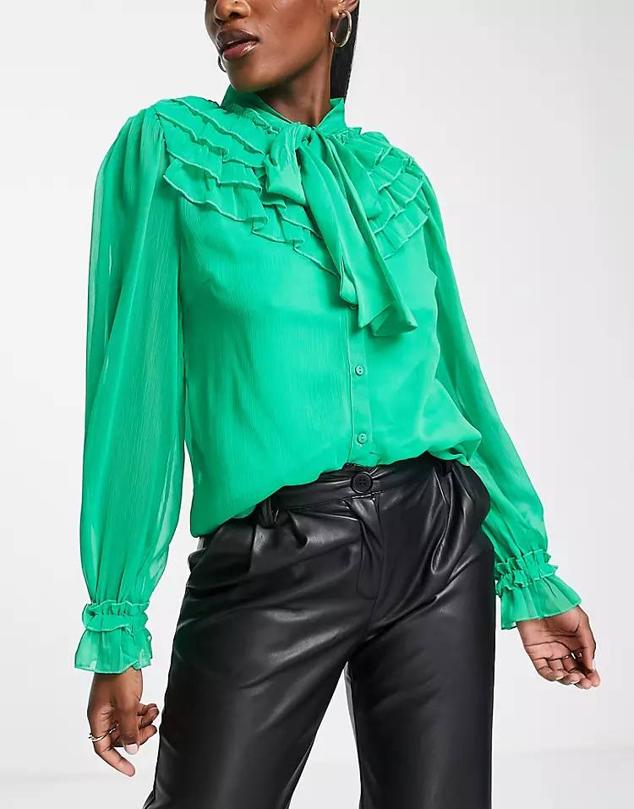 Camisa en tejido vaporoso con manga larga abullonada, detalles de volantes y lazada al cuello, color verde, de Vila. Está disponible en Asos por 34,99 euros.