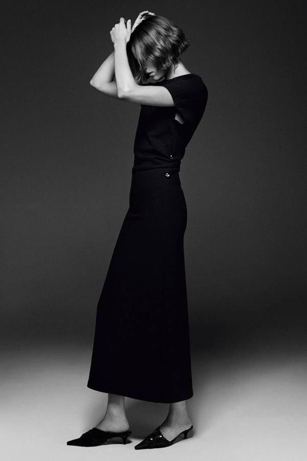 Vestido largo acomodado a la figura con manga corta, cuello redondo, detalles drapeados en los laterales y abertura trasera en el bajo, color negro, de Zara. Puedes comprarlo por 79,95 euros.