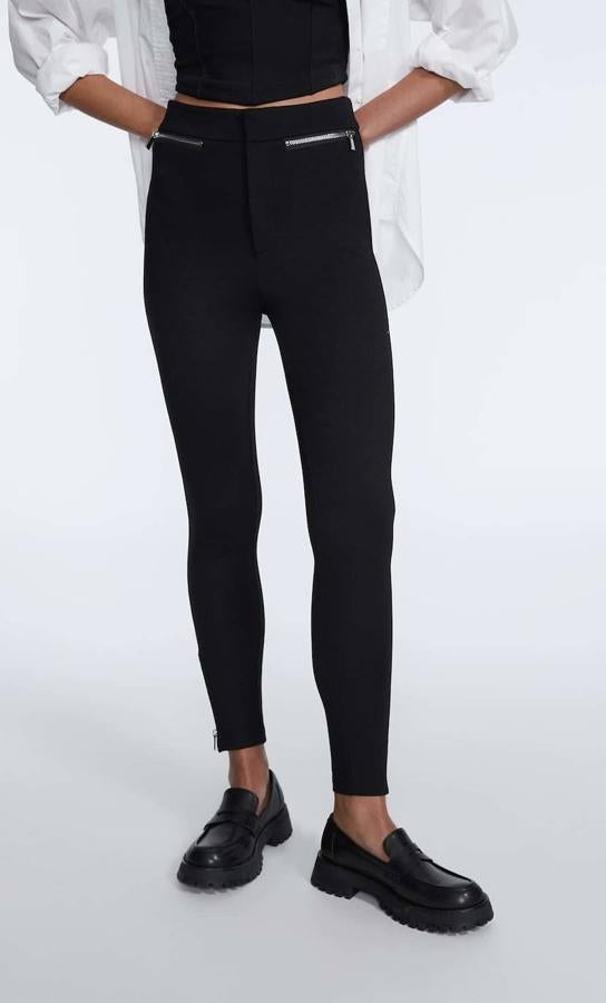 Pantalón legging en punto roma con tiro alto, pernera pitillo y cremalleras en el bajo y los bolsillos, color negro, de Stradivarius. Hazte con él por 19,99 euros. 