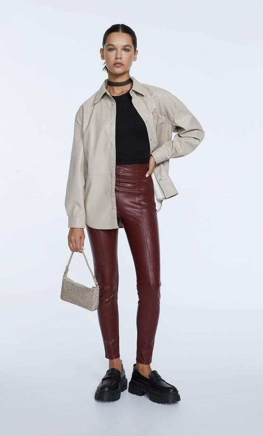 Leggings en tejido efecto piel con pernera entallada, tiro alto y costuras decorativas, en tono granate, de Stradivarius. Su coste es de 19,99 euros.