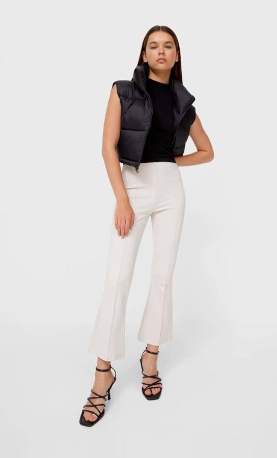 Pantalón en tejido elástico con perneras estilo flare cropped, tiro alto y detalle de nervios, color piedra, de Stradivarius. Puedes encontrarlo a 19,99 euros.