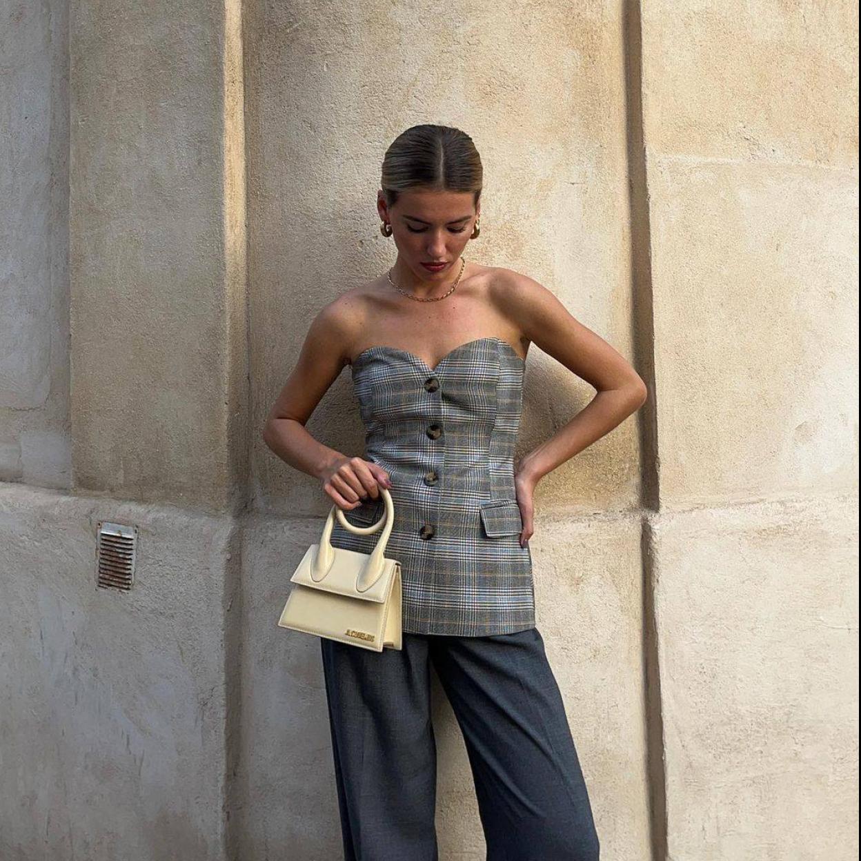 La influencer lleva un look de traje con bustier a cuadros y pantalón masculino