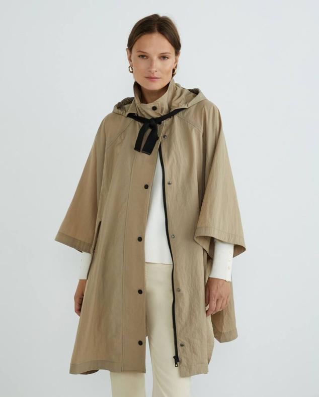 Capa de lluvia oversize con capucha ajustable, mangas amplias, bolsillos laterales con tapeta, cuello alto y doble cierre de cremallera y botones a presión, en visón, de Woman El Corte Inglés. HAzte con ella por 99,99 euros. Cómpralo aquí