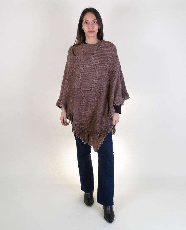 Poncho midi de punto con diseño asimétrico, cuello barco, tejido rústico con detalles trenzados y terminación de flecos, en marrón, de Kbas. Su coste es de 25,95 euros. Cómpralo aquí