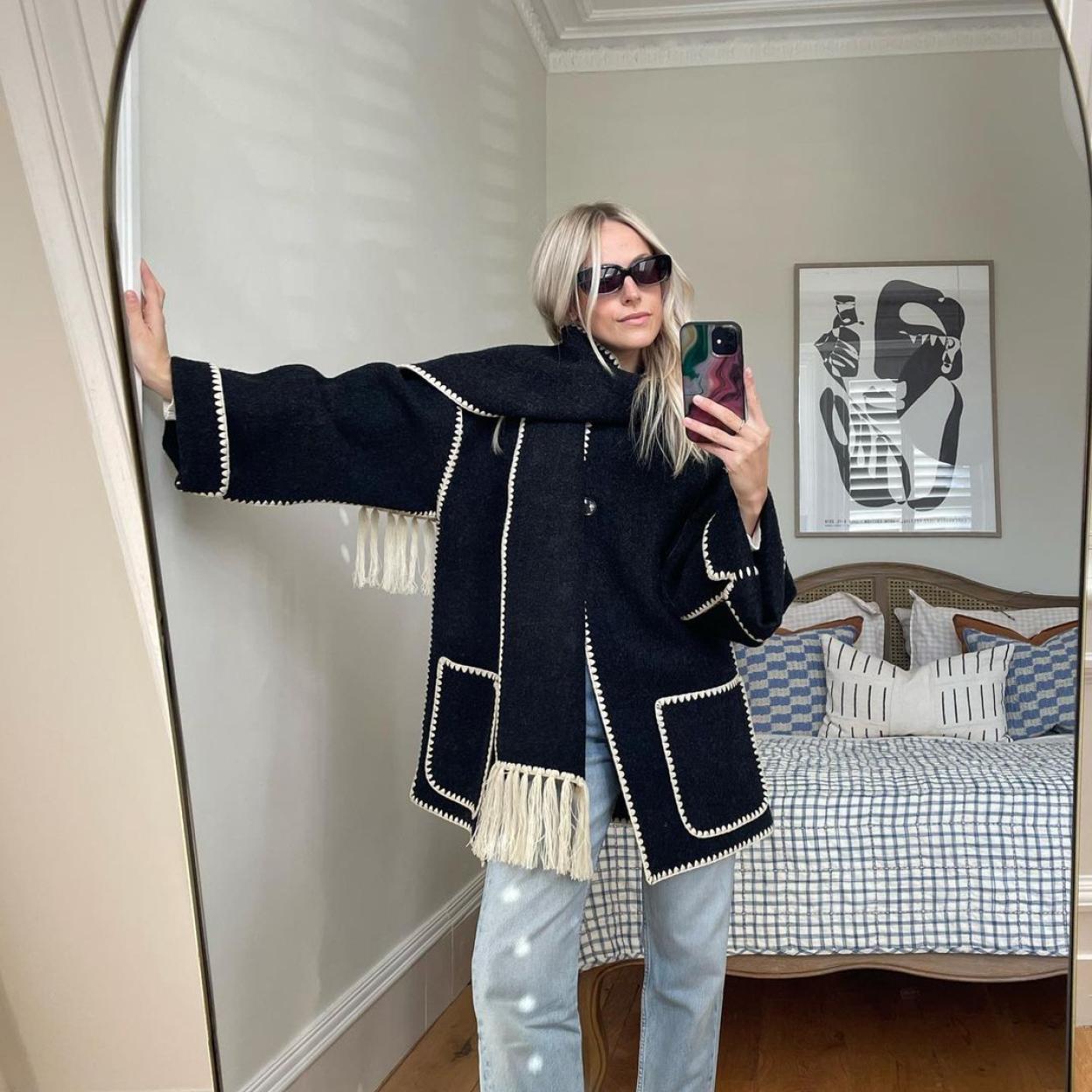 La influencer lleva unos pantalones vaqueros de tiro medio con un abrigo de color negro.