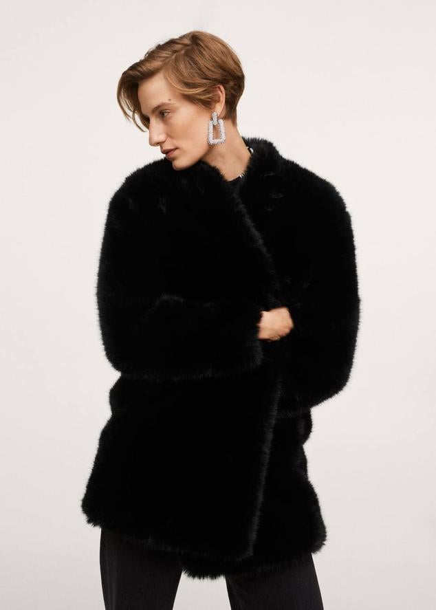 Abrigo corto de pelo con manga larga, corte relajado, bolsillos y diseño abierto, color negro, de Mango. Cuesta 79,99 euros.