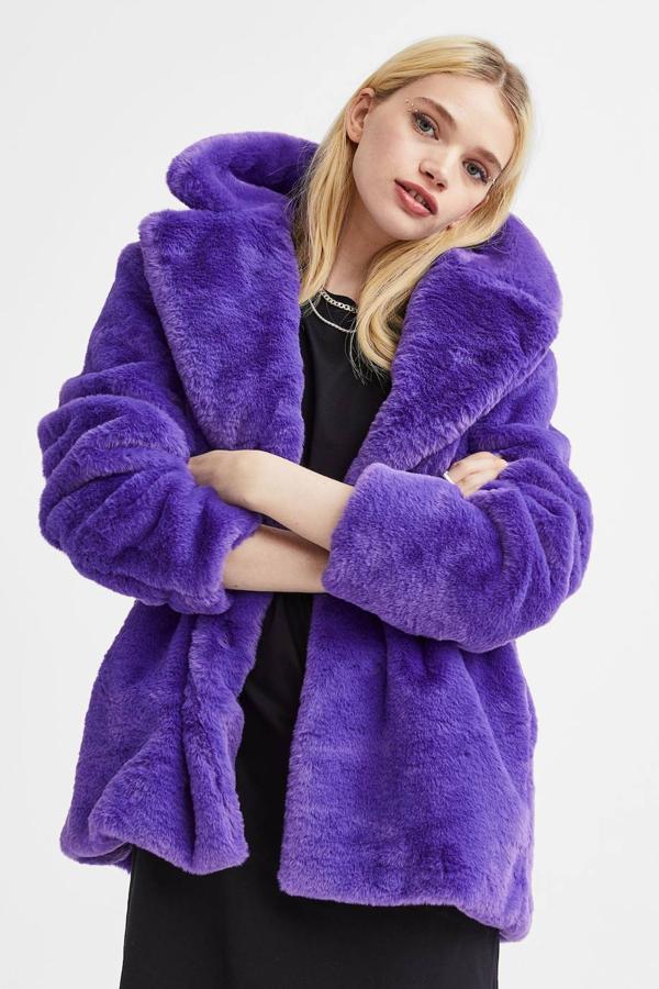 Abrigo corto de pelo con manga larga, solapas amplias, bolsillos y cierre de botonadura sencilla, en morado, de H&M. Cómpralo por 49,99 euros.