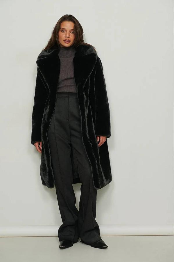 Abrigo oversize de pelo con corte relajado y largo, cuello solapa amplio y manga larga, en negro, de NA-KD. Está disponible a 159,95 euros.