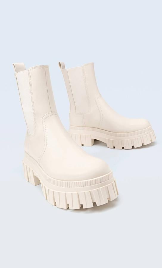 Botines tipo chelsea con suela track a tono, tirador trasero y paneles elásticos, en color crudo, de Stradivarius. Cómpralos por 39,99 euros.