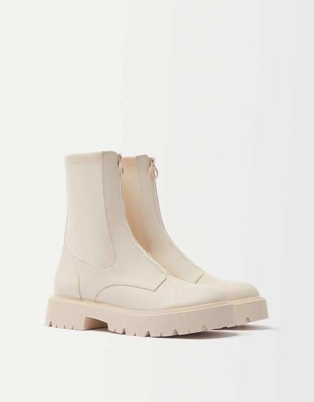 Botines con caña ajustada, cierre de cremallera frontal y suela gruesa tipo track, en crudo, de Bershka. Hazte con ellos por 35,99 euros.