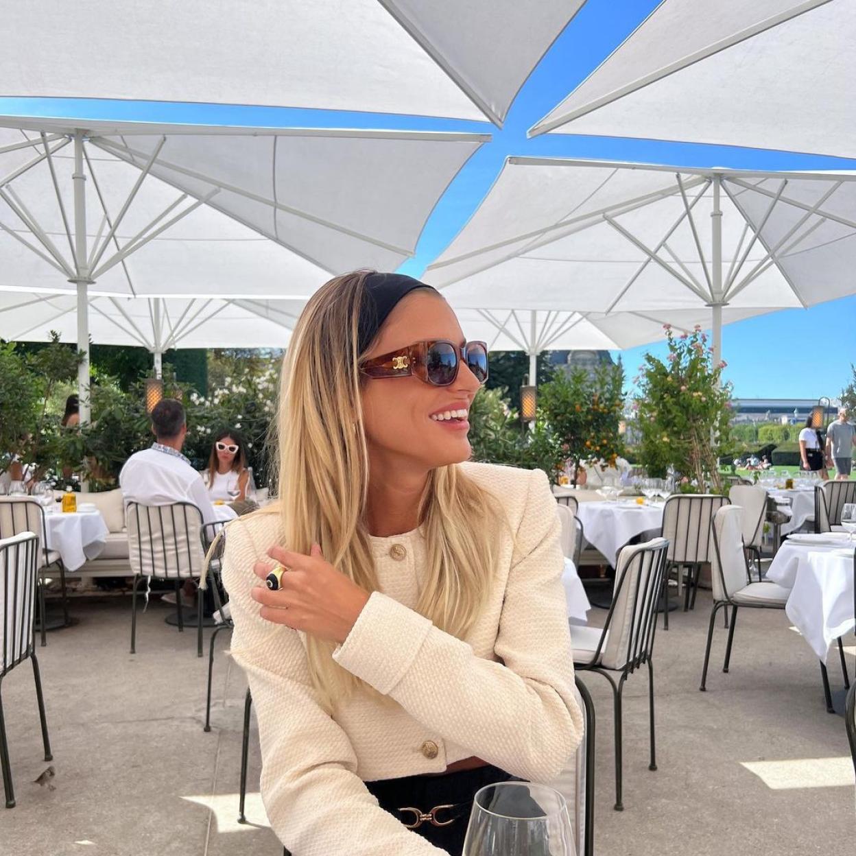 La influencer luce una chaqueta de tweed de color blanco que complementa con un turbante y unas gafas de sol.