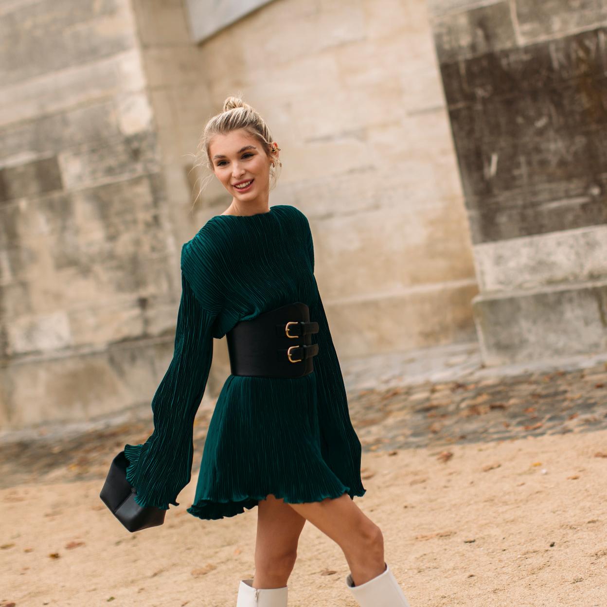 La influencer lleva un vestido de manga larga corto que combina con unas botas altas y un maxi cinturón. 