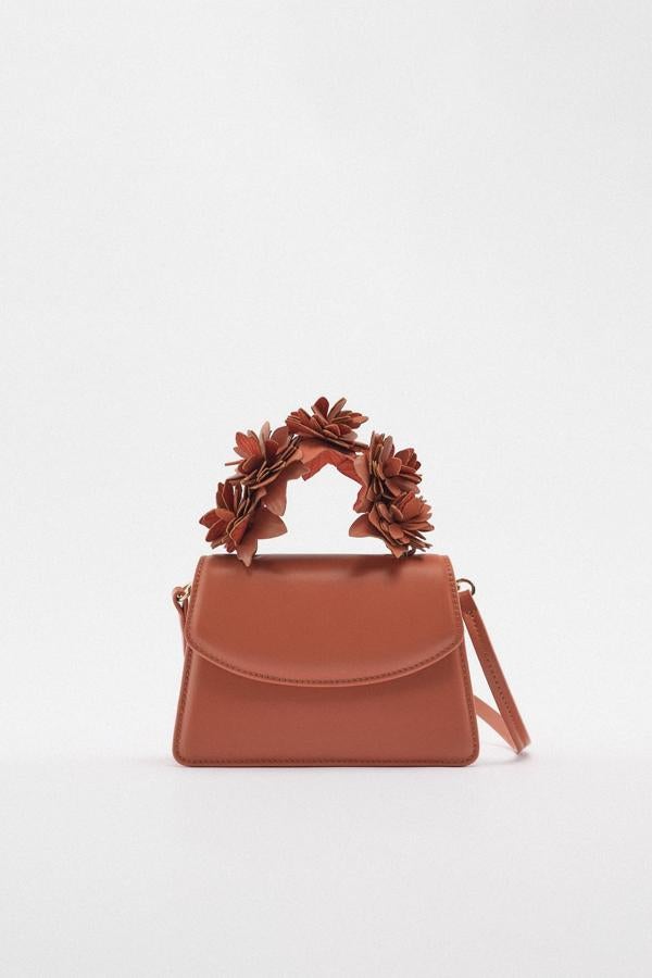 Un bolso de mano en un color que combina con todo. Bolso con flores en relieve de Zara (39,99 euros). 