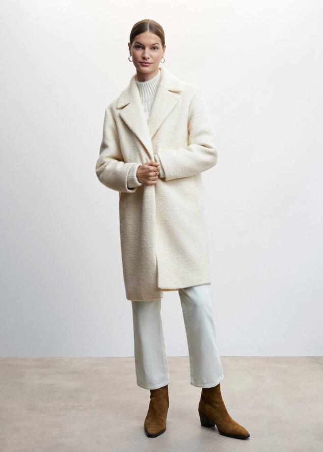 Abrigo oversize recto con silueta relajada, tejido rizo mezcla de lana, cuello solapa con muesca, bolsillos laterales y cierre de botón, color crudo, de Mango. Lo comprarás a 99,99 euros.