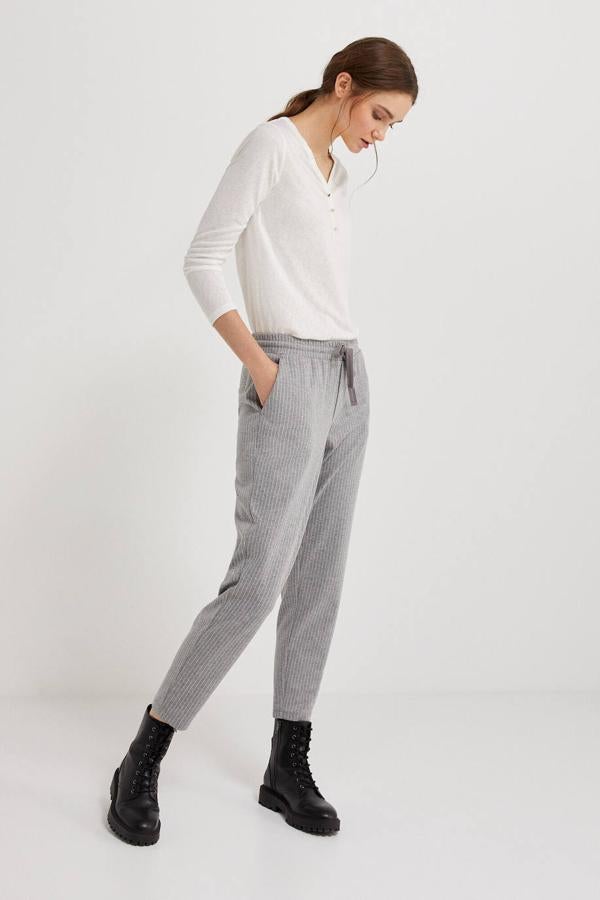 Pantalón jogger con pernera acomodada al cuerpo, bolsillos, cintura elástica con cordones y estampado de rayas, en gris claro, de Springfield. Puedes comprarlo por 25,99 euros.