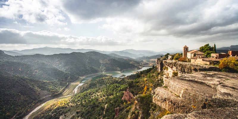 A majestic view over the mountain village of Siurana, taken from the famous Salto de la Reina Mora, with views of the dam in the valley below.