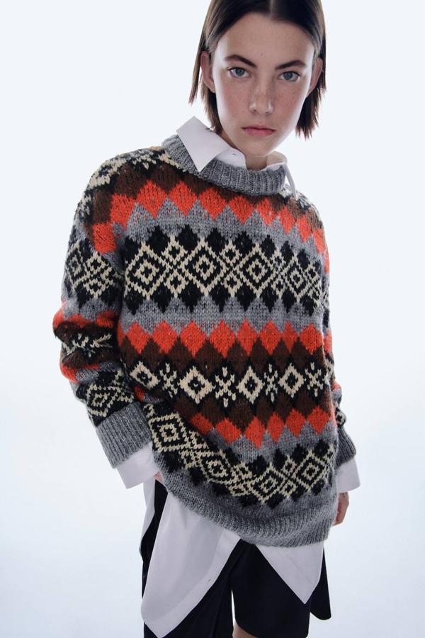 Jersey oversize en tejido de punto grueso con jacquar de cenefas en tonos, negro, rojo, marrón, gris y crudo, de Zara. Cuesta 39,95 euros.