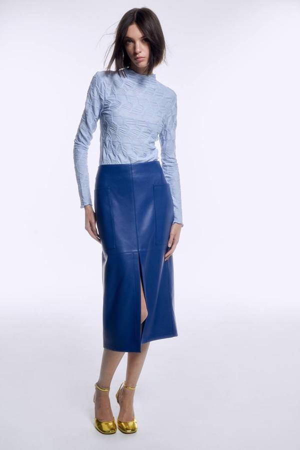 Falda en tejido de polipiel con diseño de tubo, tiro alto, abertura frontal en el bajo y bolsillos laterales, color azul, de Sfera. Su coste es de 35,99 euros.