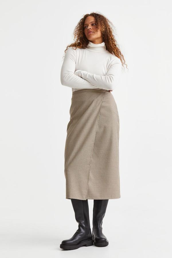 Un diseño que favorece a todo tipo de siluetas. Falda midi cruzada con estampado de cuadros de H&M (29,99 euros). 
