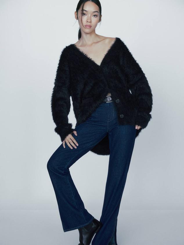 Cárdigan de punto oversize con silueta relajada, manga larga, escote de pico, cierre de botones y tejido efecto pelo, color negro, de Massimo Dutti. Está disponible por 129 euros.