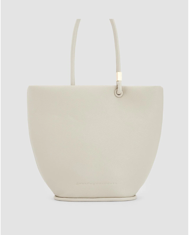 Bolso tipo capazo de material reciclado de textura granulada en color crudo. Podrás hacerte con el con un descuento del 20%. Es de Adolfo Domínguez. Precio rebajado: 119 €. Cómpralo aquí