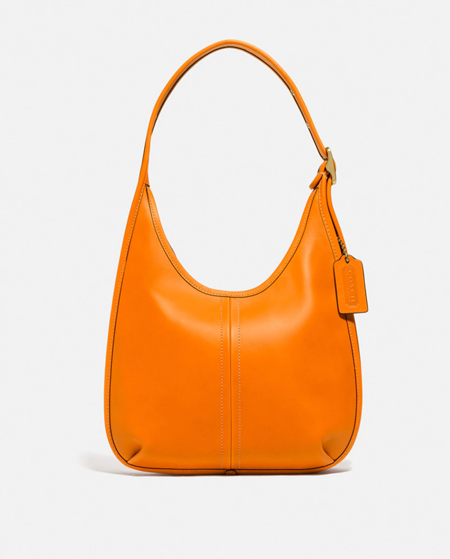 Bolso de hombre con diseño hobo con el color más vibrante de la temporada, el naranja. Cuenta con un descuento del 30%. Es de Coach. Precio rebajado: 385 €. Cómpralo aquí