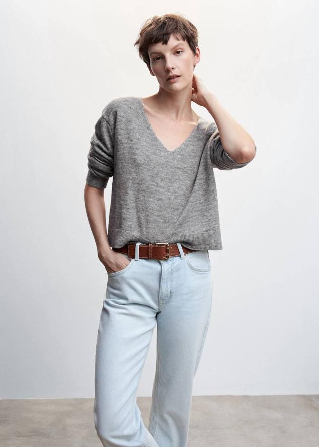 Jersey en tejido de punto suave con manga larga, corte amplio y escote de pico, en tono gris jaspeado, de Mango. Tiene un precio de 25,99 euros.