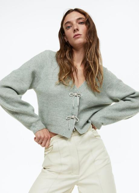 Imagen - Cárdigan en punto de canalé con lazos de strass, 29,99€.