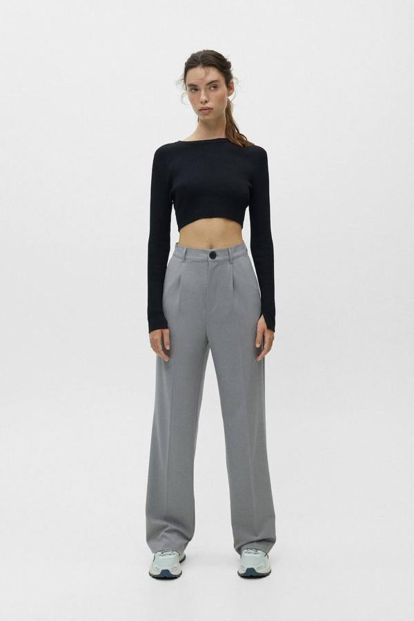 Pantalones fluidos con pernera ancha y recta, tiro alto y pinzas, color gris, de Pull&Bear. Su precio es de 25,99 euros.