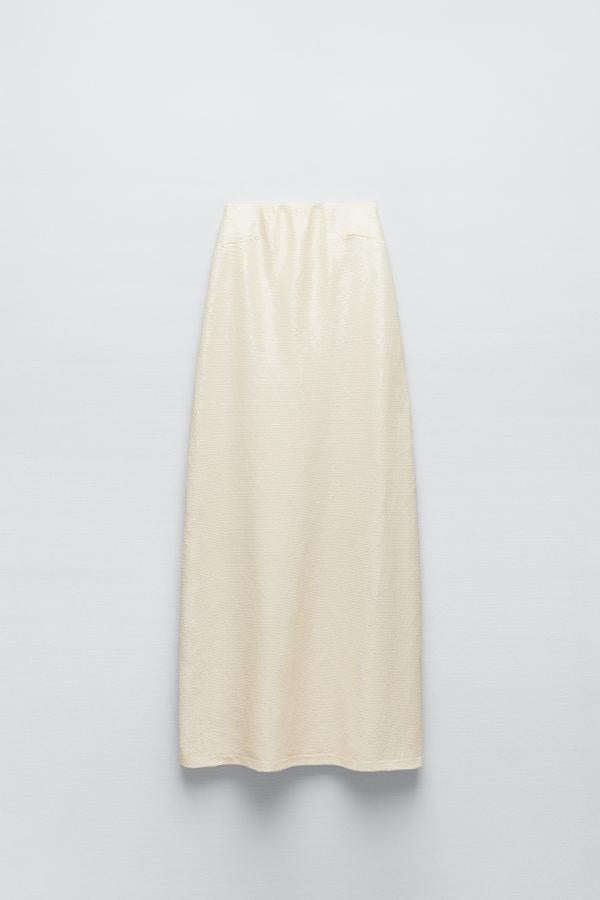 Vestido largo de escote recto elástico con aplicación de lentejuelas sobre fondo crudo. Es de Zara. Precio: 69,95 €.